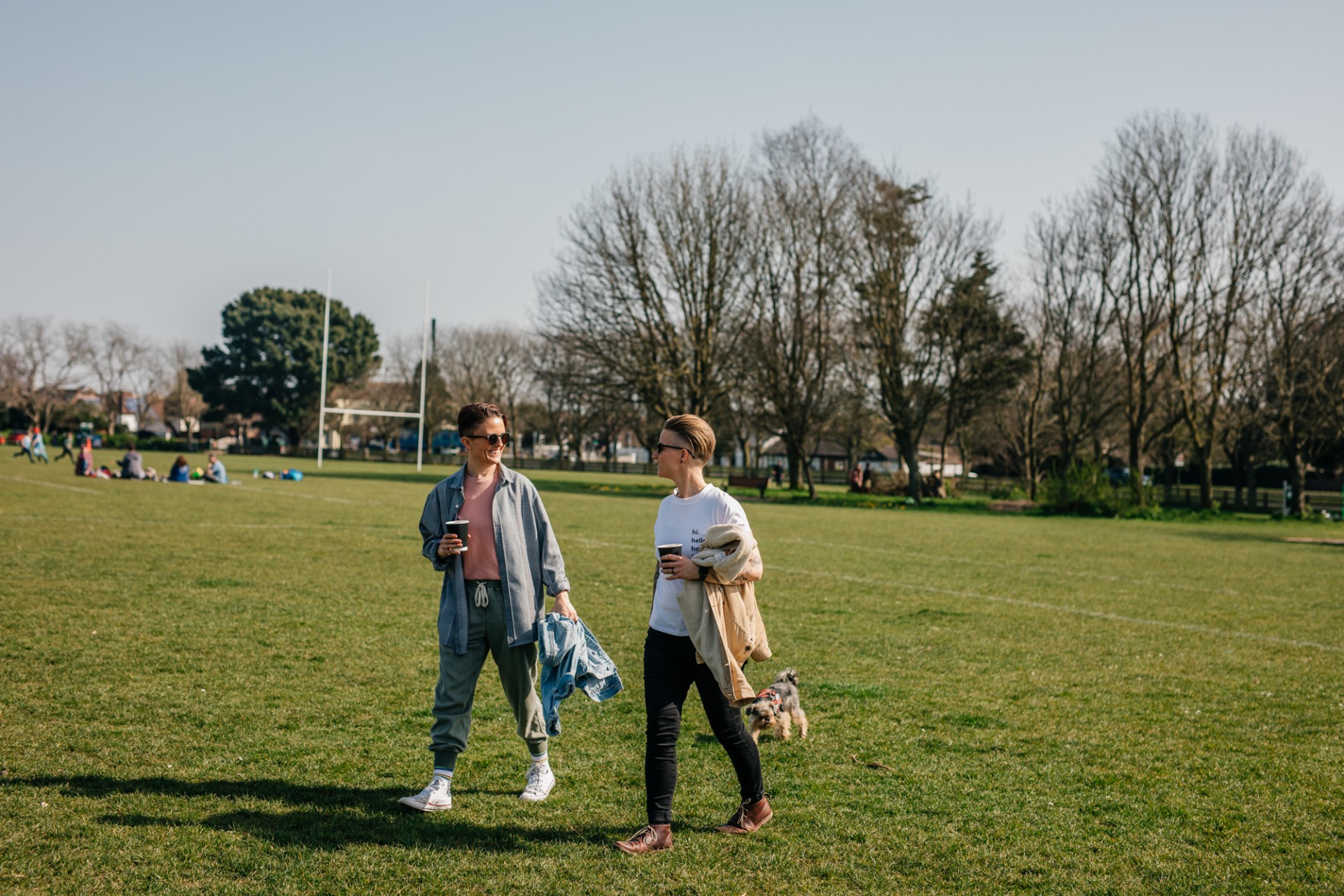 Two people walking and talking in a park.