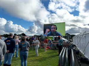 Circus skills taking place in front of a big screen.