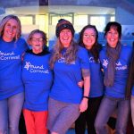 A group of 4 people smiling with Cornwall Mind t shirts on.