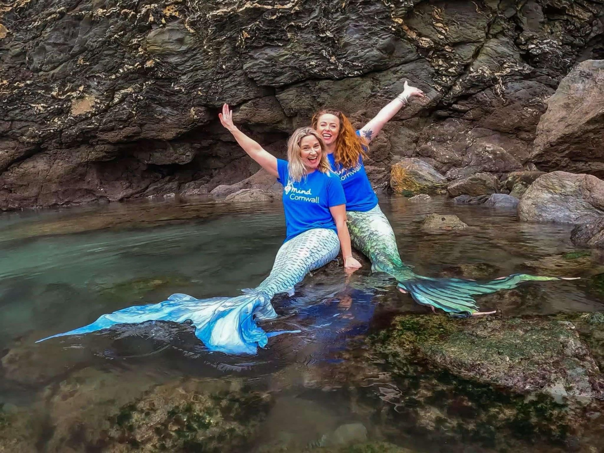 Two females dressed as Mermaids in a rock pool