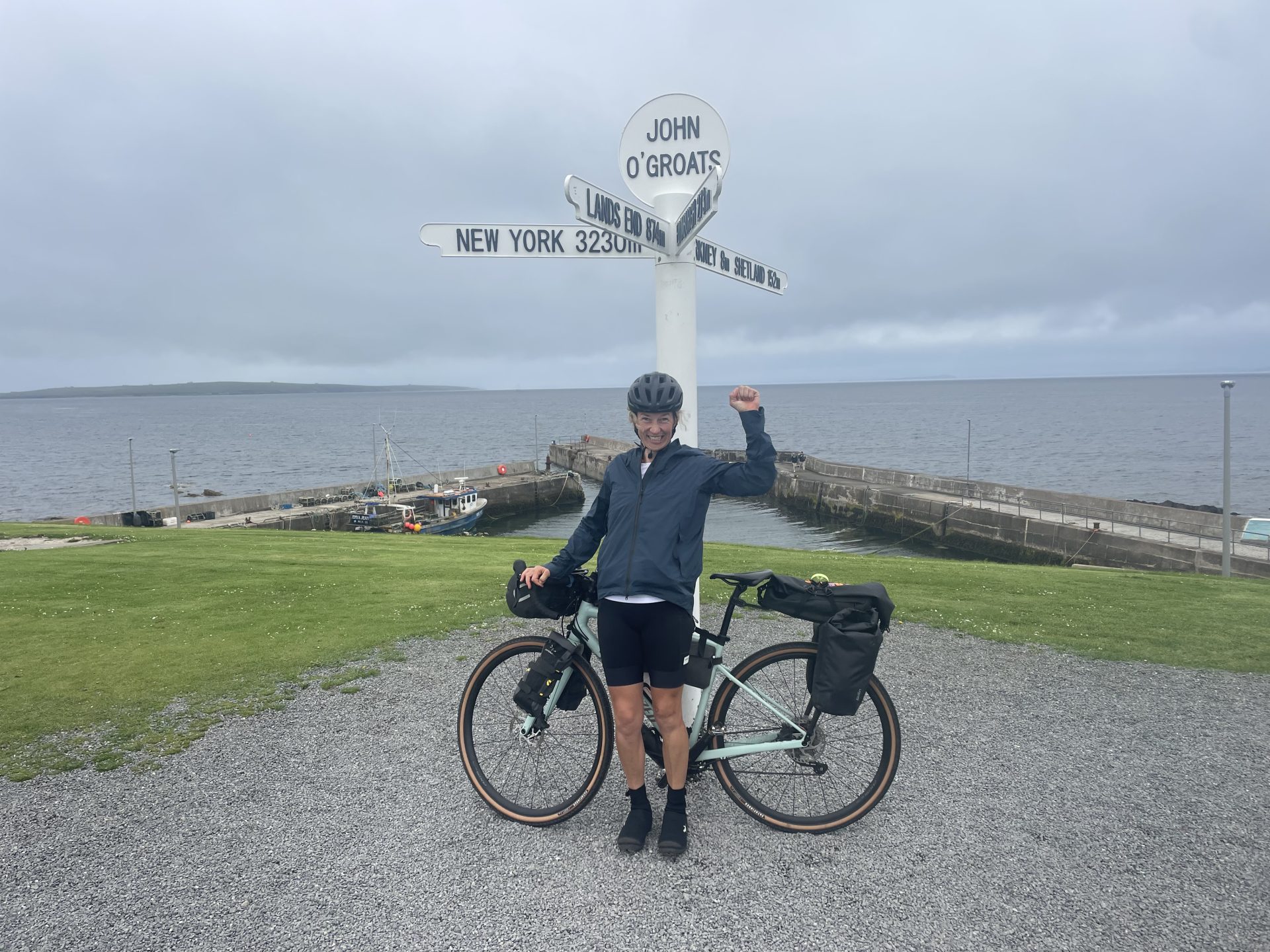 Katy staning with her bike and The John O Groats sign