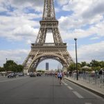 Cyclists riding under the Eiffel Tower