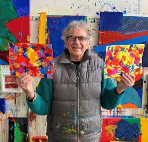 Artist Anthony Frost holding up some of his artwork.