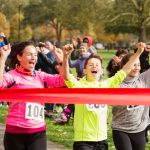 A group of people cheering as they cross the finishing line