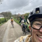 People cycling, one is waving