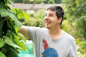Person smiling as they do some gardening.